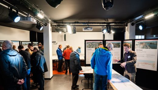 personen in een ruimte waarin infoborden en posters staan