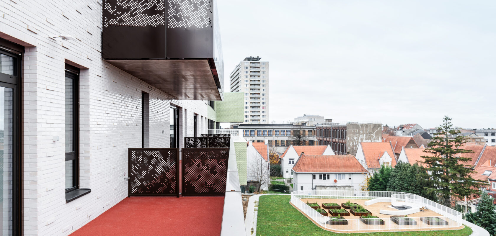 Vue extérieure du complexe pédagogique Mutsaard. Vous voyez une terrasse et un toit vert