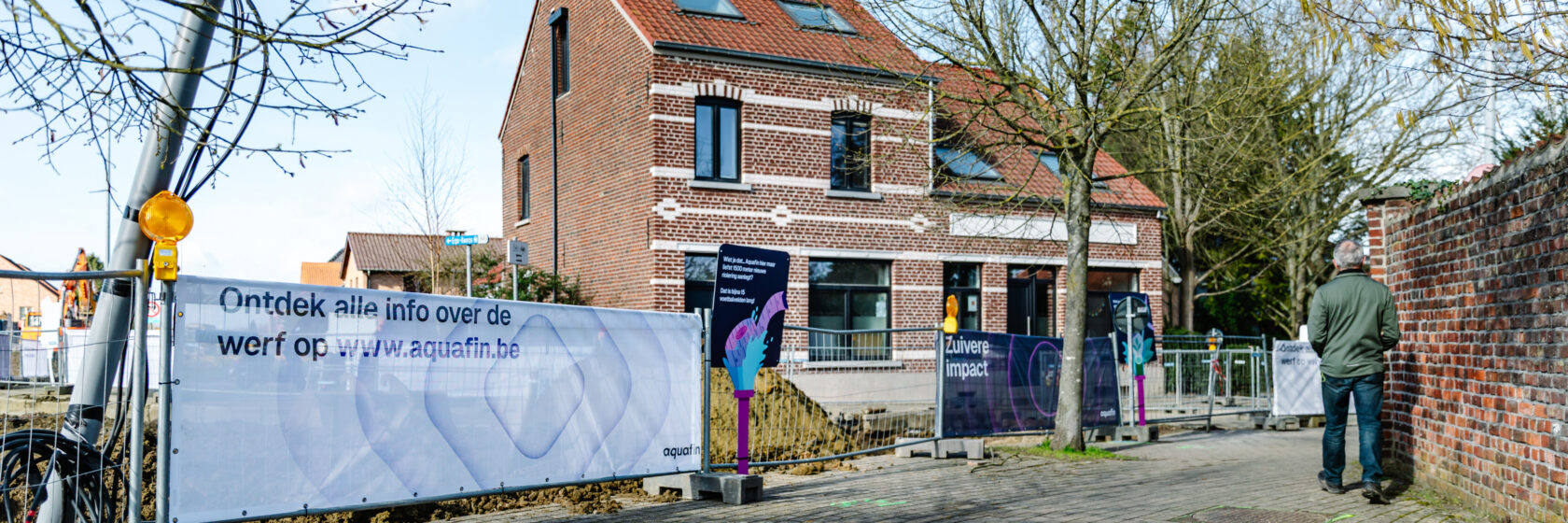 huis met aan de linkerzijde hek waraan een witte banner hangt