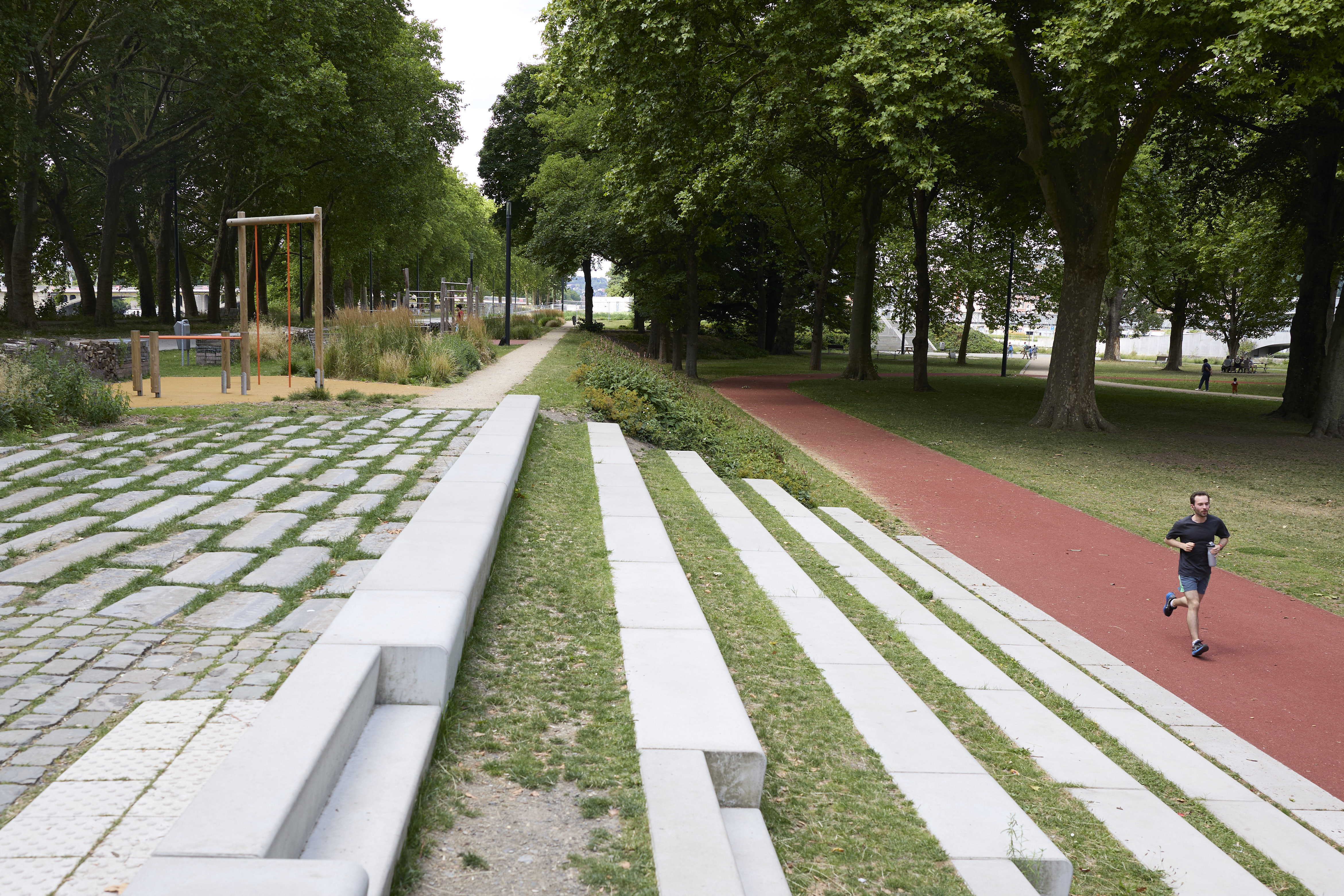 beeld van het park met looppiste waarop jogger loopt