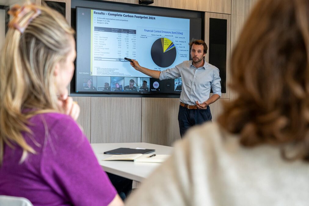 2 personen die naar een presentatie kijken op groot scherm