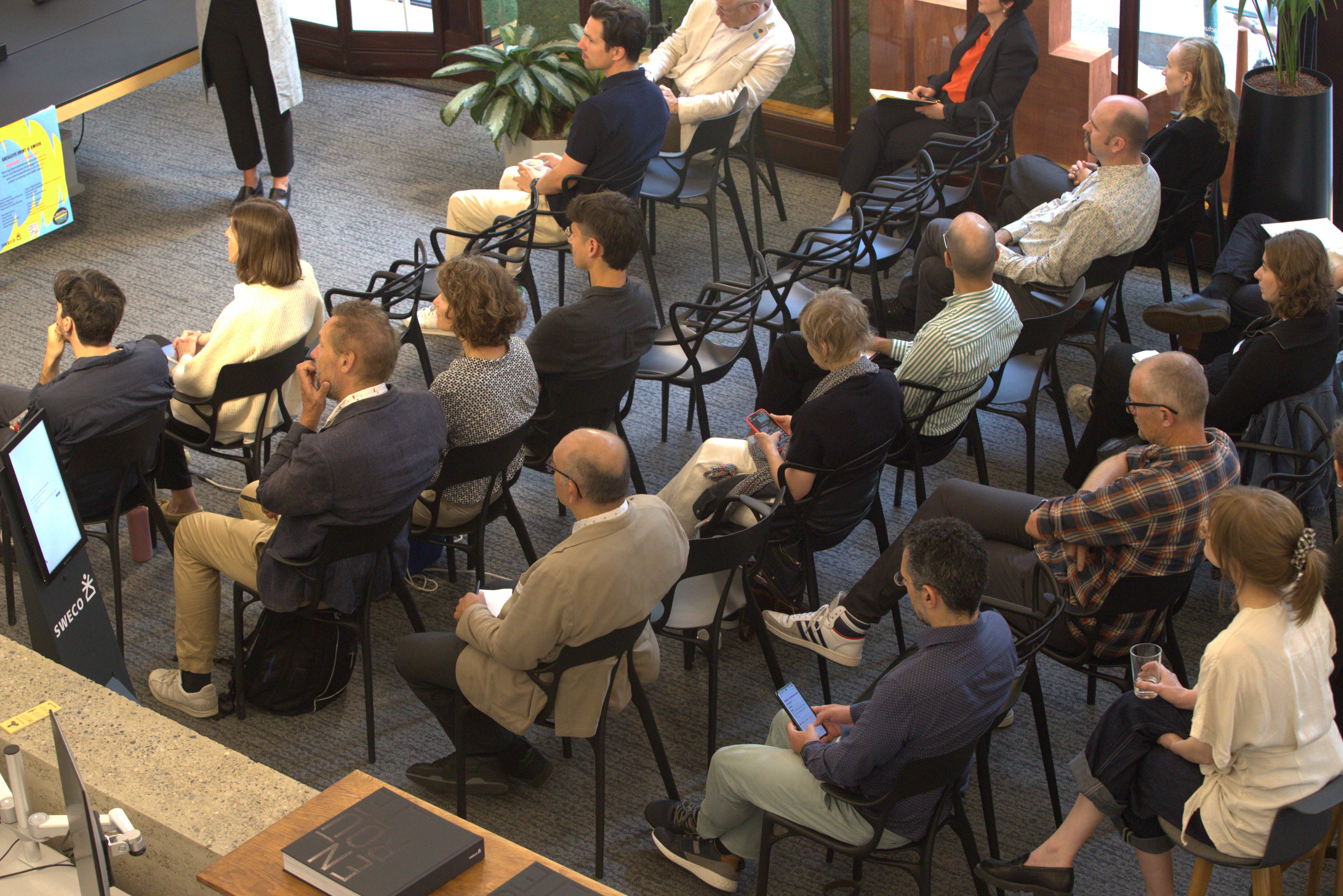 publiek dat zit en luistert naar een lezing