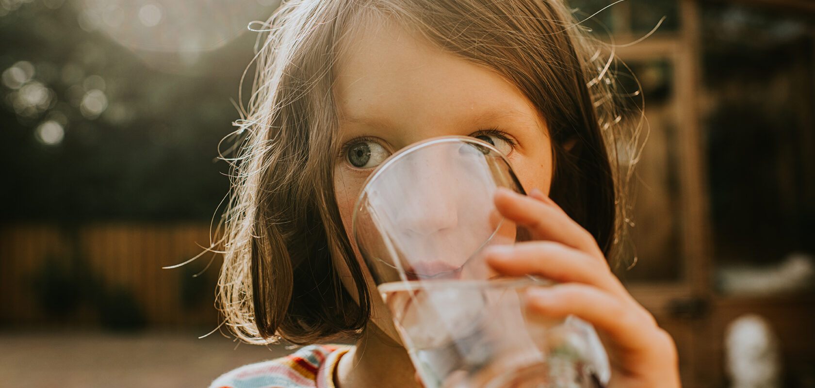 A little girl drinks a refreshing glass of water